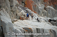 Rock climbers, prepare to climb White Water Wall, located in Freycinet National Park, Tasmania, Australia.