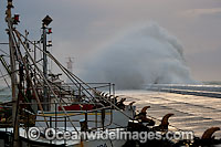 Huge wave breaking against harbor wall during a storm. Kalk Bay, Cape Town, South Africa