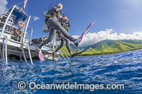 Divers step off a dive boat into the Pacific Ocean out from Ukumehame, Maui, Hawaii.