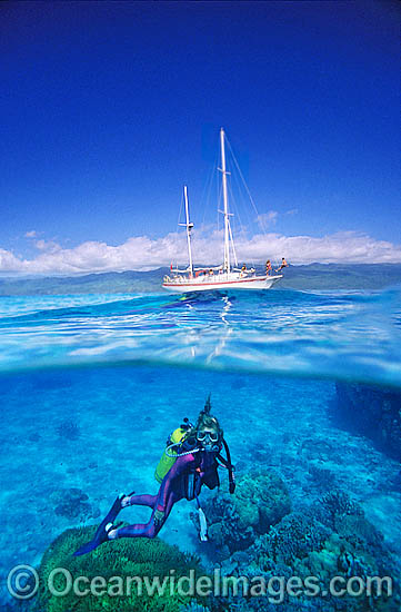 Scuba Diver beneath sailing yacht photo