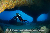 Underwater photographer exploring and photographing a tropical coral reef cave at Christmas Island, Indian Ocean, Australia.