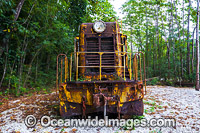 Rusty abandoned diesel train engine resting beside tropical rainforest, Christmas Island, Indian Ocean, Australia.