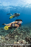 Divers with underwater scooters exploring a coral reef off Maui, Hawaii, USA.